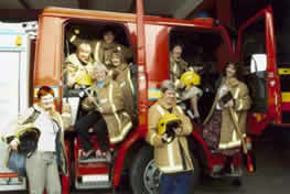 Calendar girls posing in fire engine